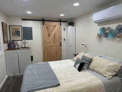 a bedroom with a large bed with a wooden door at Country Cottage with beautiful views in Saugerties
