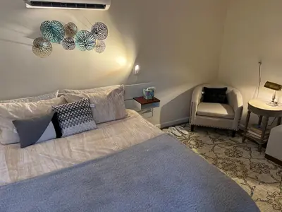a bedroom with a large bed and a chair at Country Cottage with beautiful views in Saugerties