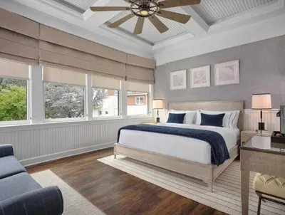 a bedroom with a bed and a ceiling fan at The Northport Hotel in Northport