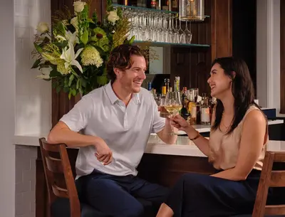 a man and a woman sitting at a bar drinking wine at The Northport Hotel in Northport