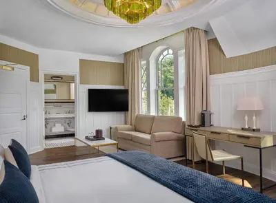 a bedroom with a bed and a desk and a couch at The Northport Hotel in Northport
