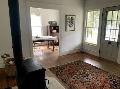 a living room with a table and a rug on the floor at Bovina House in Bovina Center