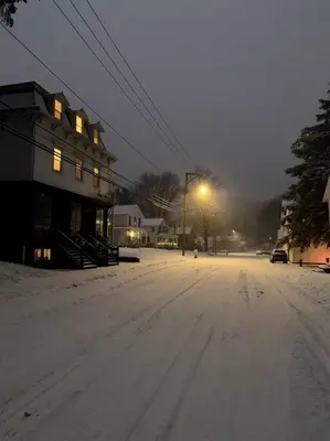 a snow covered street with a building and a street light at Bovina House in Bovina Center