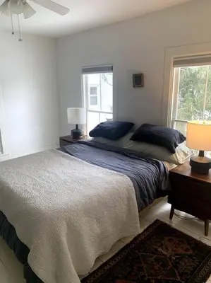a white bedroom with two beds and a window at Bovina House in Bovina Center