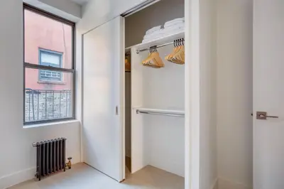 a hallway with a closet with a window at Blueground Chelsea elev wd nr 8th Ave NYC-1450 in New York