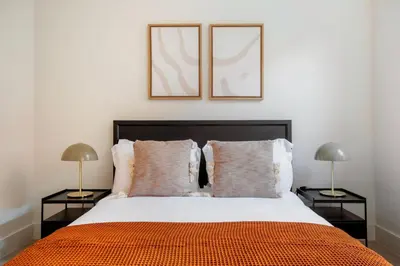 a bedroom with a large bed with two lamps at Blueground Chelsea elev wd nr 8th Ave NYC-1450 in New York