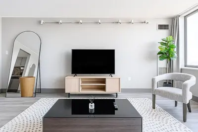 a living room with a tv and a chair at Modern Condo DWNTN Hartord XL Center GYM in Hartford