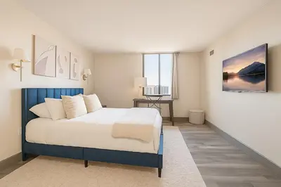 a bedroom with a blue and white bed and a desk at Downtown Hartford Condo - Bushnell Park - Convention Center in Hartford