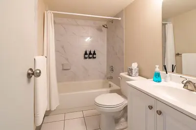 a bathroom with a toilet and a tub and a sink at Downtown Hartford Condo - Bushnell Park - Convention Center in Hartford