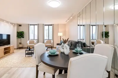 a living room with a table and chairs and a television at Downtown Hartford Condo - Bushnell Park - Convention Center in Hartford