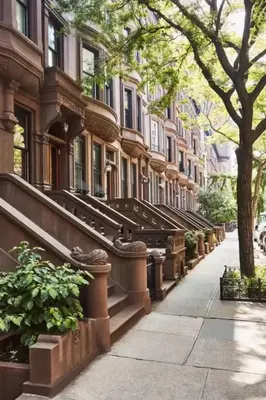 a building with a row of stairs on a city street at Townhouse in Uptown Manhattan in New York