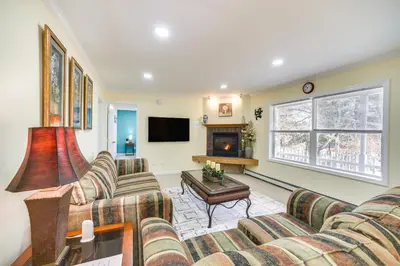 a living room with two couches and a fireplace at Cozy Lake Luzerne Home - 1 Mi to Wayside Beach! in Lake Luzerne