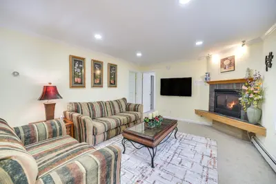 a living room with two couches and a fireplace at Cozy Lake Luzerne Home - 1 Mi to Wayside Beach! in Lake Luzerne