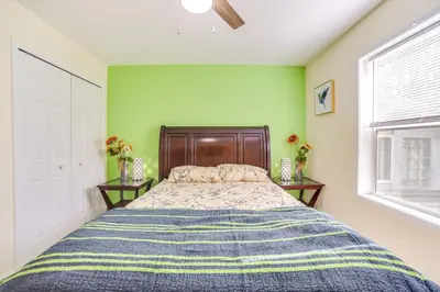 a bedroom with a bed and two tables with flowers at Cozy Lake Luzerne Home - 1 Mi to Wayside Beach! in Lake Luzerne