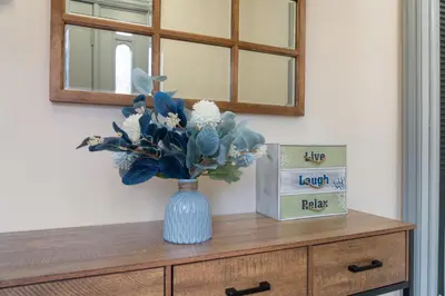 a blue vase with flowers on top of a dresser at Gorgeous 5BD w Hot-Tub & Pool villa located in the middle of Pocono in East Stroudsburg