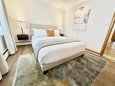 a white bedroom with a large bed and a rug at Downtown New Haven by Yale & Little Italy - AO Destinations in New Haven