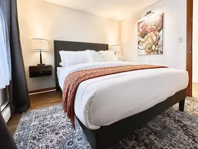 a bedroom with a large bed and a rug at Downtown New Haven by Yale & Little Italy - AO Destinations in New Haven