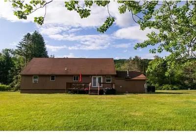 a brown house with a grassy yard in front of it at Cozy Palace in Livingston Manor