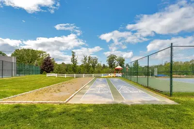 a tennis court with a fence around it at Jellystone Park Birchwood Acres in Greenfield Park