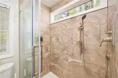 a bathroom with a shower with a glass door at Jellystone Park Birchwood Acres in Greenfield Park