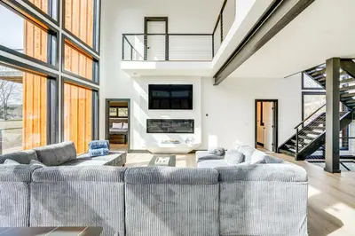 a living room with two couches and a staircase at Custom Windham Mtn Villa with Pool, Theater and Views! in Windham