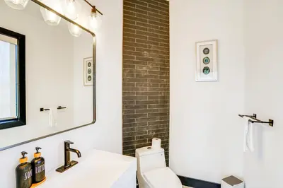 a bathroom with a sink and a toilet and a mirror at Custom Windham Mtn Villa with Pool, Theater and Views! in Windham