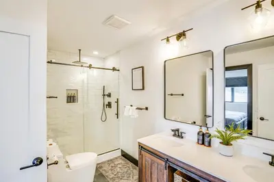 a bathroom with a sink and a toilet and a mirror at Custom Windham Mtn Villa with Pool, Theater and Views! in Windham