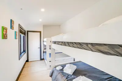 a room with two bunk beds and a staircase at Custom Windham Mtn Villa with Pool, Theater and Views! in Windham