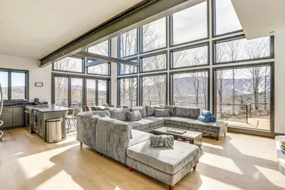 a large living room with a large glass wall at Custom Windham Mtn Villa with Pool, Theater and Views! in Windham