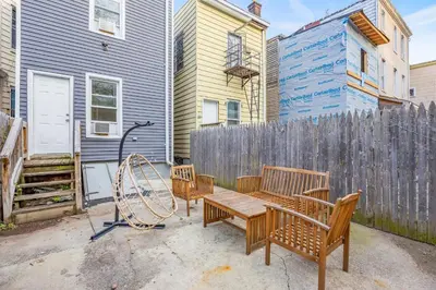 a backyard with a wooden bench and a fence at Newark's Family Favorite Place in Newark