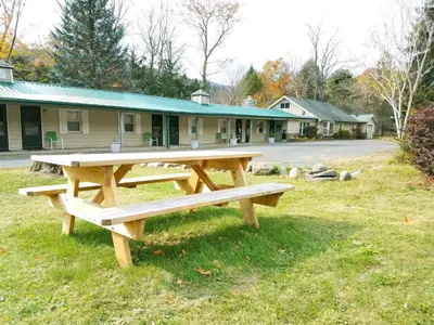 a wooden picnic table in front of a building at Black Bear Lodge in Prattsville