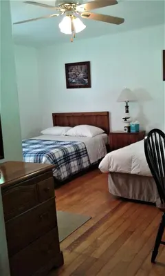 a bedroom with two beds and a ceiling fan at Black Bear Lodge in Prattsville