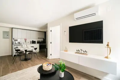 a living room with a tv on a white wall at Massive 1BR w Private Patio in Upper East Side in New York