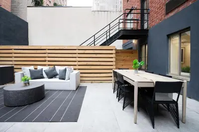 a patio with a white couch and a table and chairs at Massive 1BR w Private Patio in Upper East Side in New York