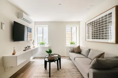 a living room with a couch and a table at Massive 1BR w Private Patio in Upper East Side in New York