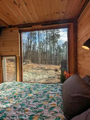 a bed in a room with a large window at The Dome house near Hunter and Hudson in Catskill