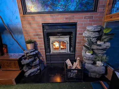 a brick fireplace in a living room with plants at The Dome house near Hunter and Hudson in Catskill