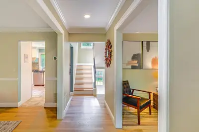 a hallway of a home with a chair and stairs at NYC-Area Escape Near River, Trails and MTA! in Ossining