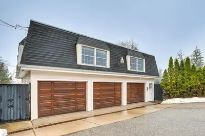 a house with brown garage doors on a street at 7 Mi to Newark Montclair Vacation Rental in Montclair