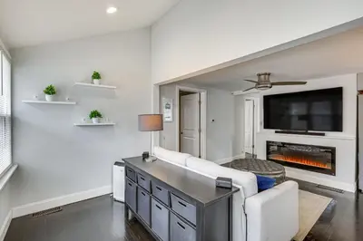a living room with a fireplace and a tv at Modern Terryville Cottage with Deck and Lake View! in Terryville