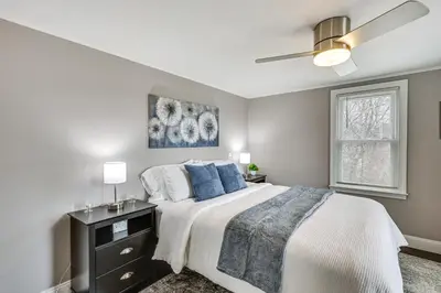 a bedroom with a bed and a ceiling fan at Modern Terryville Cottage with Deck and Lake View! in Terryville