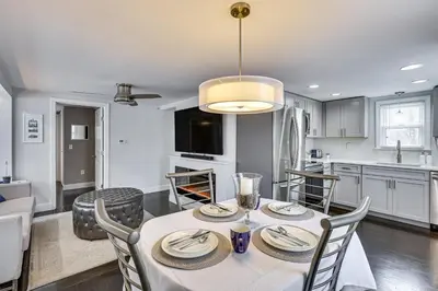 a kitchen and dining room with a table and chairs at Modern Terryville Cottage with Deck and Lake View! in Terryville
