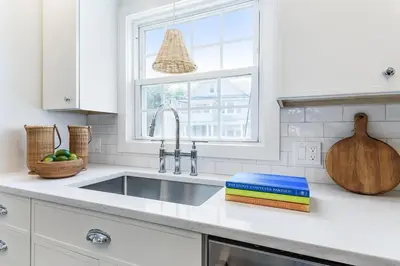 a white kitchen with a sink and a window at Stay at Black Rock Harbor in Bridgeport