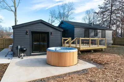 a black tiny house with a barrel in the yard at New Paltz Zen Wellness Cabin w/ Hot Tub in New Paltz
