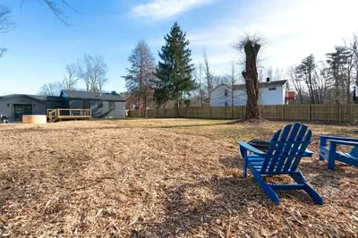 a blue chair sitting in a yard next to a tree at New Paltz Zen Wellness Cabin w/ Hot Tub in New Paltz