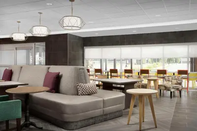 a lobby with a couch and tables and chairs at Home2 Suites By Hilton Poughkeepsie in Poughkeepsie