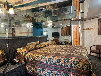 a hotel room with a bed and a mirror at Royal Motel in Secaucus