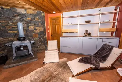 a living room with a fireplace and a stove at Luxury Mountain Mansion Huge Pool, Sauna, 7000sqft in Windham