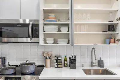a kitchen with white cabinets and a sink at SWJ544 - Chic 1BR in the Heart of NYC in New York