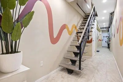 a staircase in a hallway with a mural on the wall at SWJ544 - Chic 1BR in the Heart of NYC in New York
